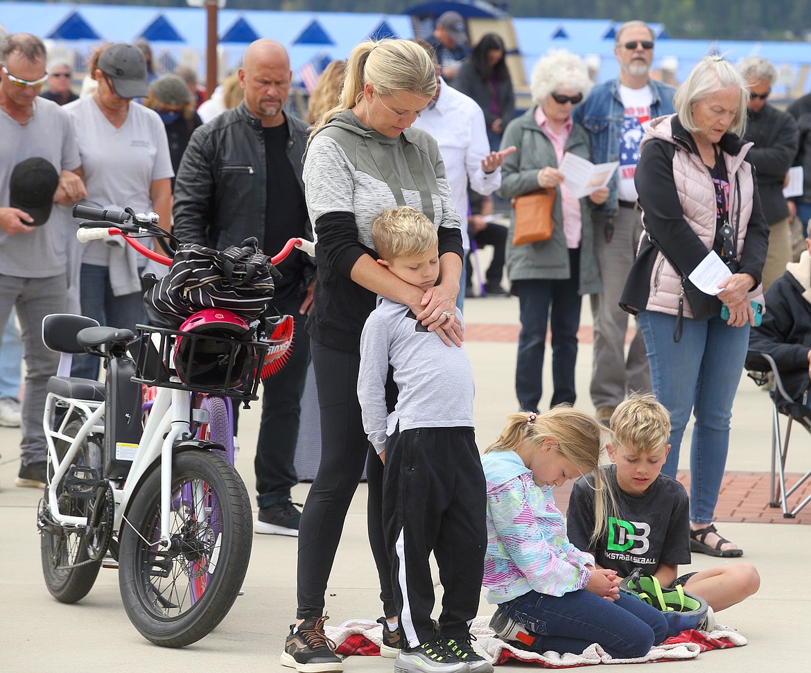 BILL BULEY/Press 
 Brianna Adams holds son Cannon while daughter Berlyn and son Aven bow their heads during the National Day of Prayer at McEuen Park on Wednesday.