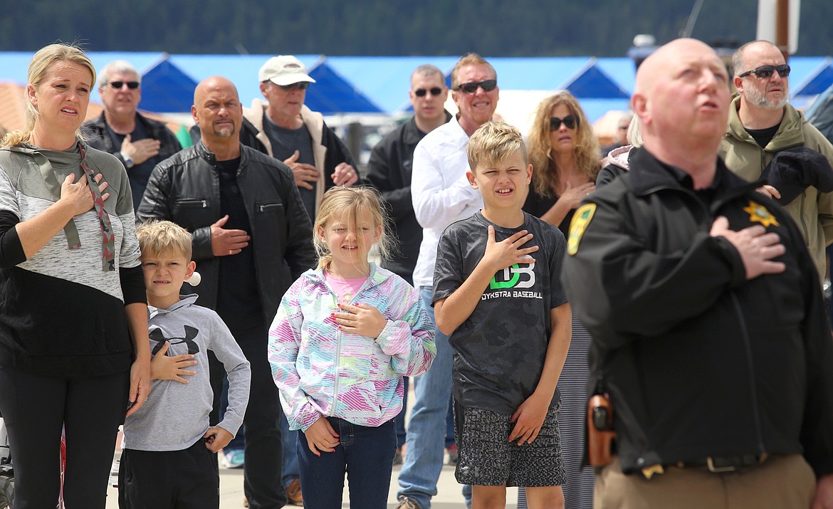 BILL BULEY/Press 
 Brianna Adams and children Cannon, Berlyn and Aven recite the Pledge of Allegiance, led by Kootenai County Sheriff Ben Wolfinger, foreground, during the National Day of Prayer at McEuen Park on Thursday.