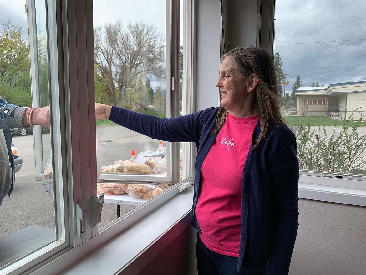 Amy Privitt, executive director of Spirit Lake nonprofit Cup of Grace, which serves weekly free meals, hands a bag of bread to a client. Innovia Foundation provided a $1,000 grant to support this nonprofit to help with food purchases.