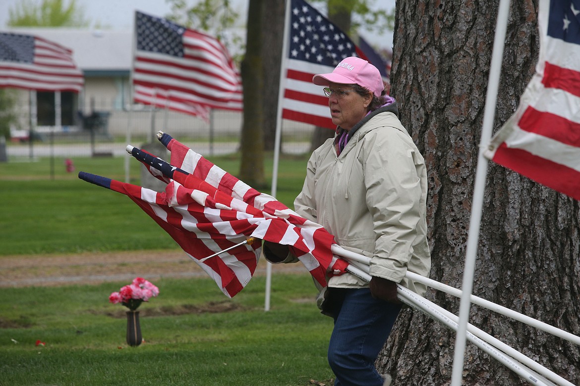 BILL BULEY/Press 
 Sally Kohn carries flags at Evergreen Cemetery on Friday.