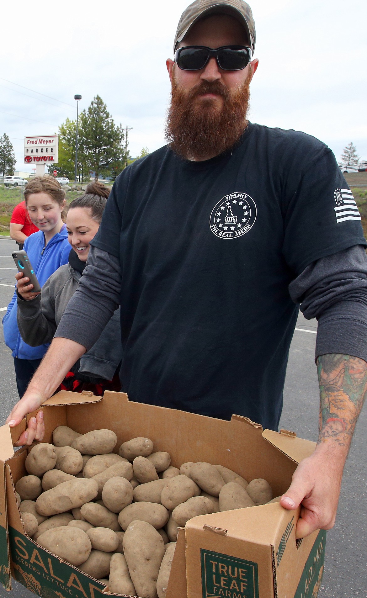 Chad Catron holds up the last of the potatoes that were given away Saturday.