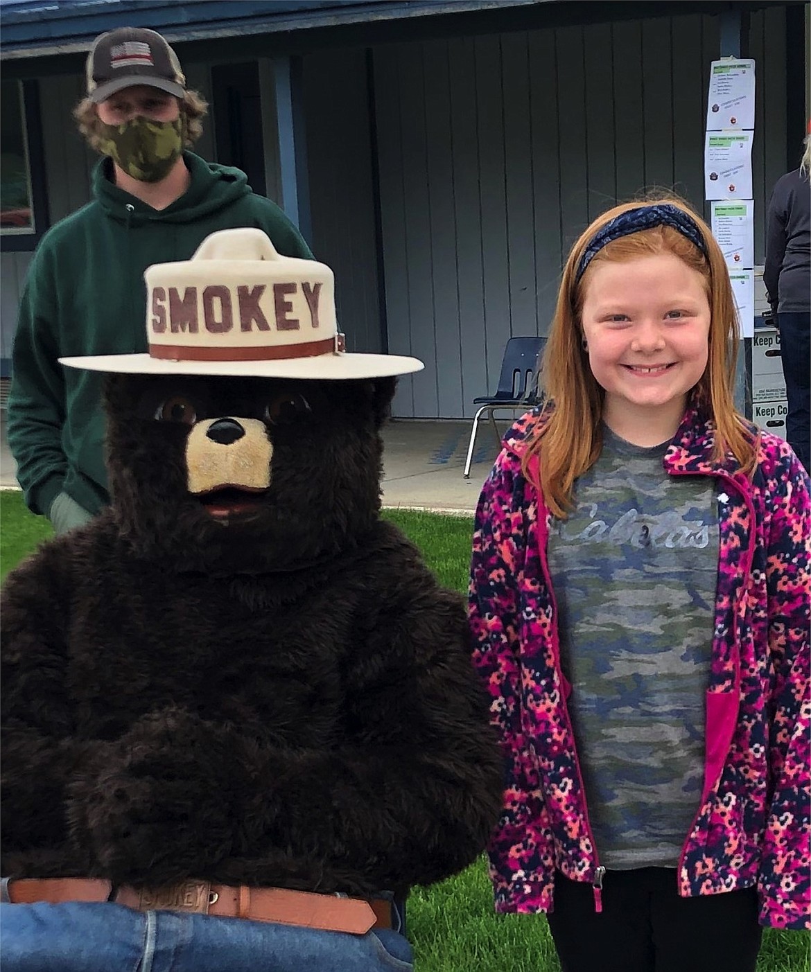 Idaho second grade second place winner Ava Ackerman of Priest River Elementary gets her photo taken with Smokey Bear. Also pictured is Tyler Zandhuisen, Priest Lake IDL firefighter and Smokey helper.