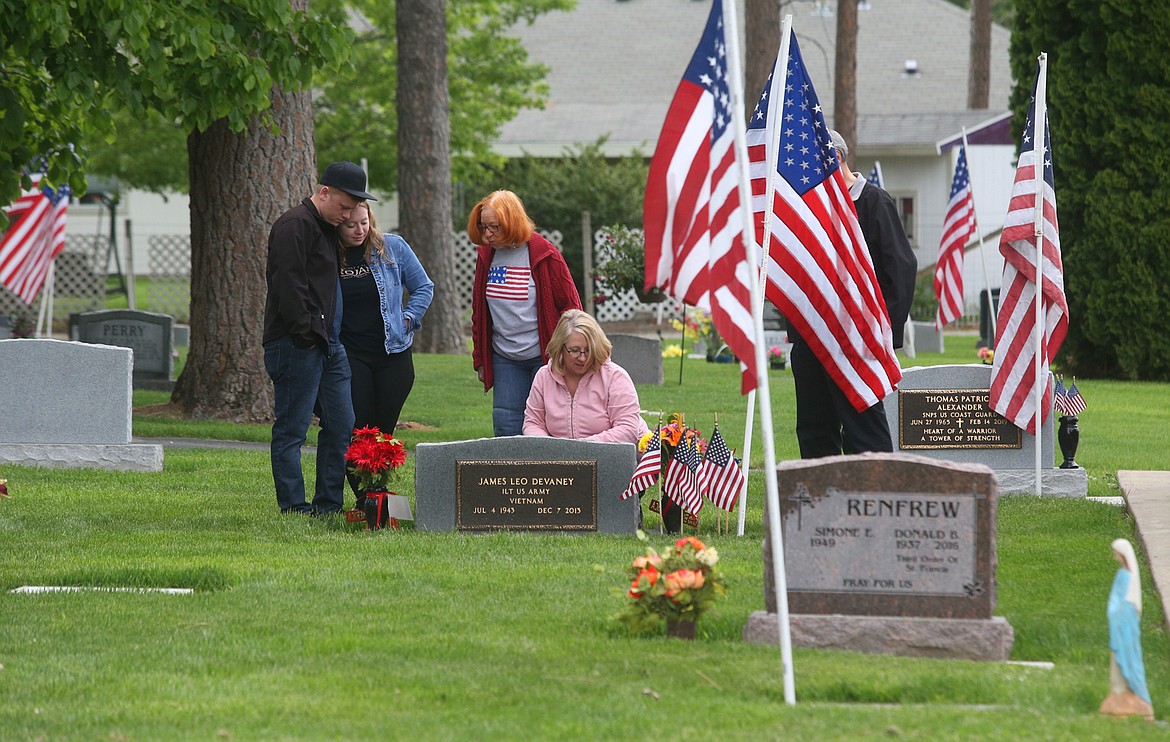 BILL BULEY/Press 
 A family gathers at a gravesite at Evergreen Cemetery on Monday.
