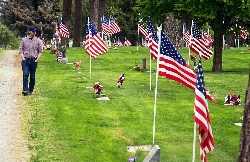 BILL BULEY/Press 
 Chris Matthews of Post Falls walks along the path at Evergreen Cemetery shortly before Monday's Memorial Day ceremony.