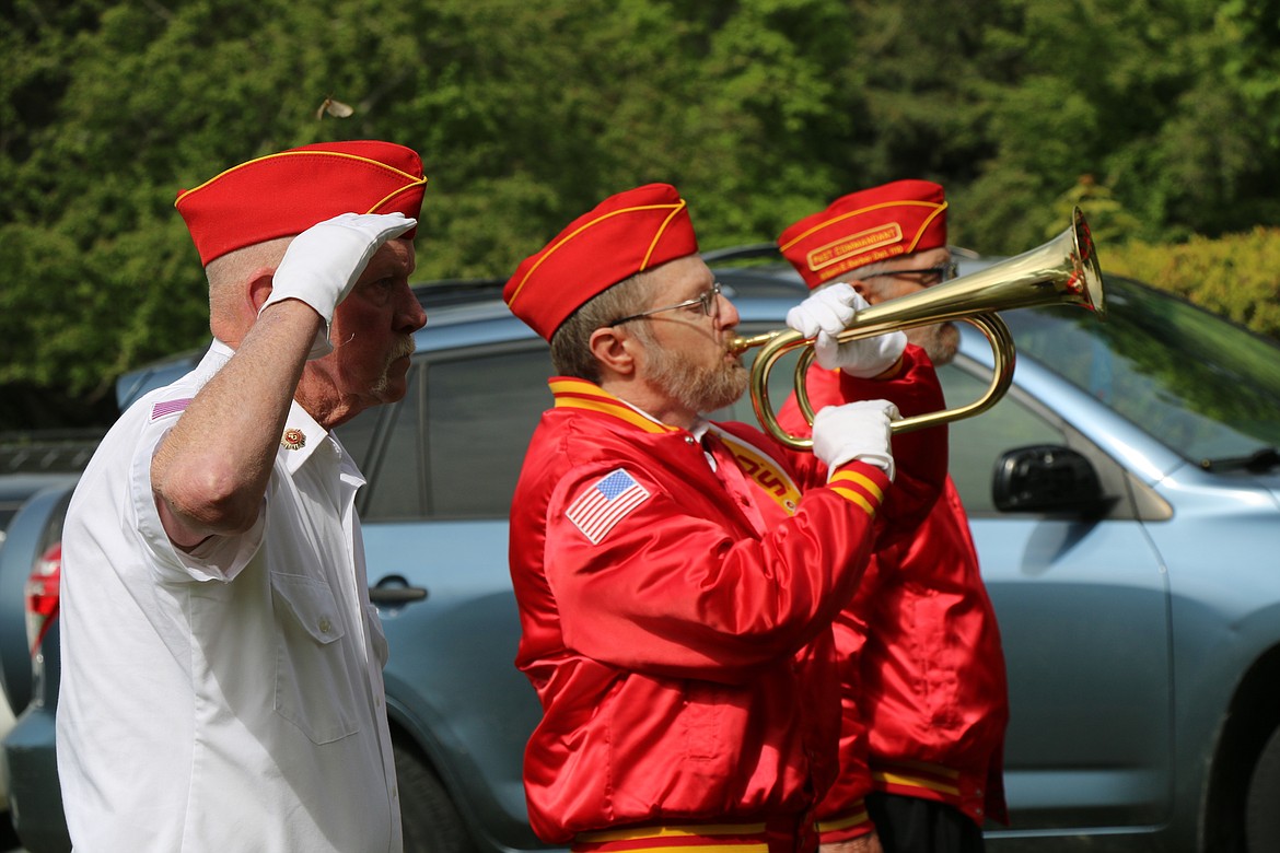 (Photo by CAROLINE LOBSINGER) 
 A members of the Marine Corps League salutes as another plays "Taps" at Monday's Memorial Day tribute at Pinecrest Cemetery in Sandpoint.