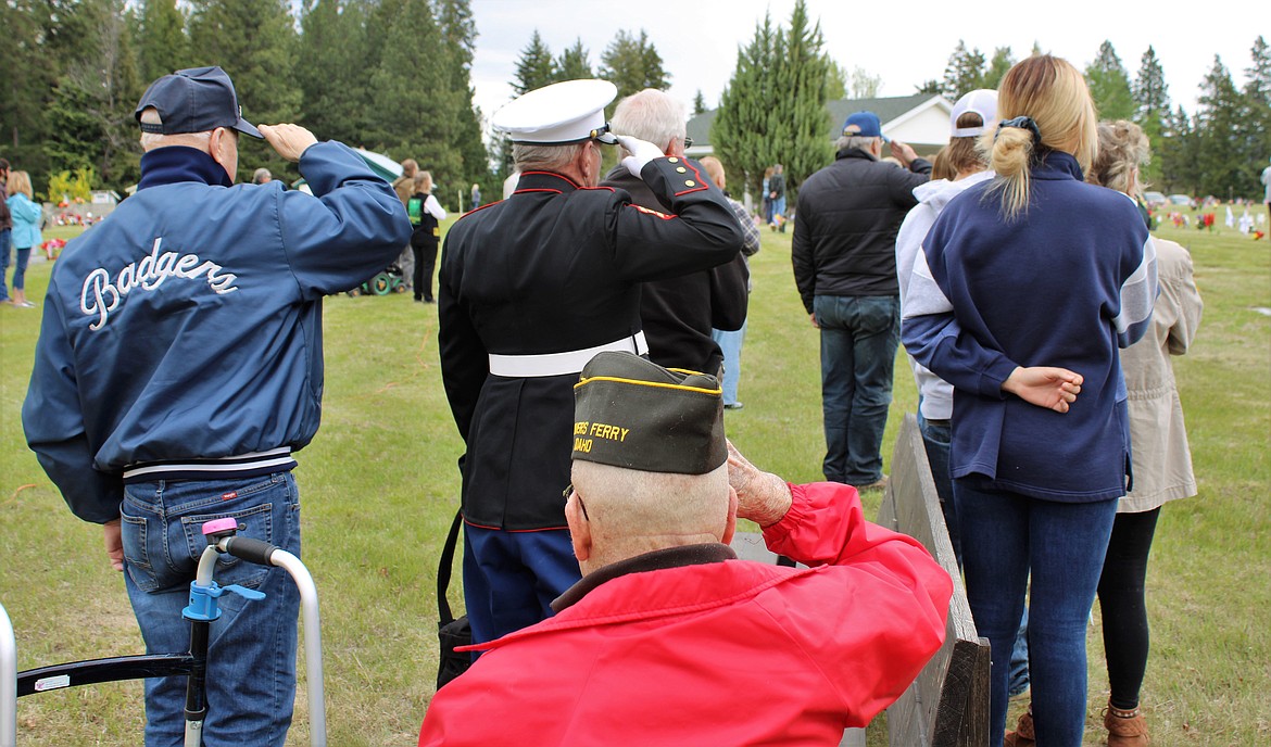 (Photo by TONIA BROOKS) 
 Local residents stand at attention during Monday's Memorial Day tribute.