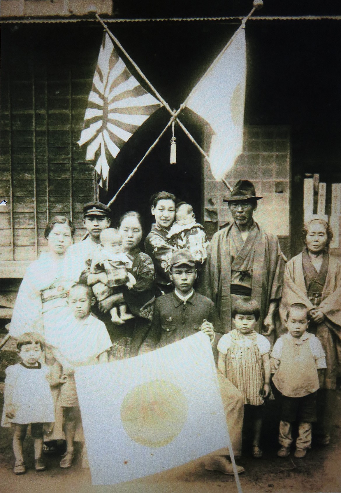 Mitaro Horiya (seated with flag) was a 27-year-old logistics officer aboard a supply ship heading to battle in 1944 when his ship was struck by an American torpedo. He left behind a wife and a 1-year-old son. 
 The son, Noburu Horiya, now 77, received the flag this year from the St. Maries legion post. 
  
 Courtesy photo