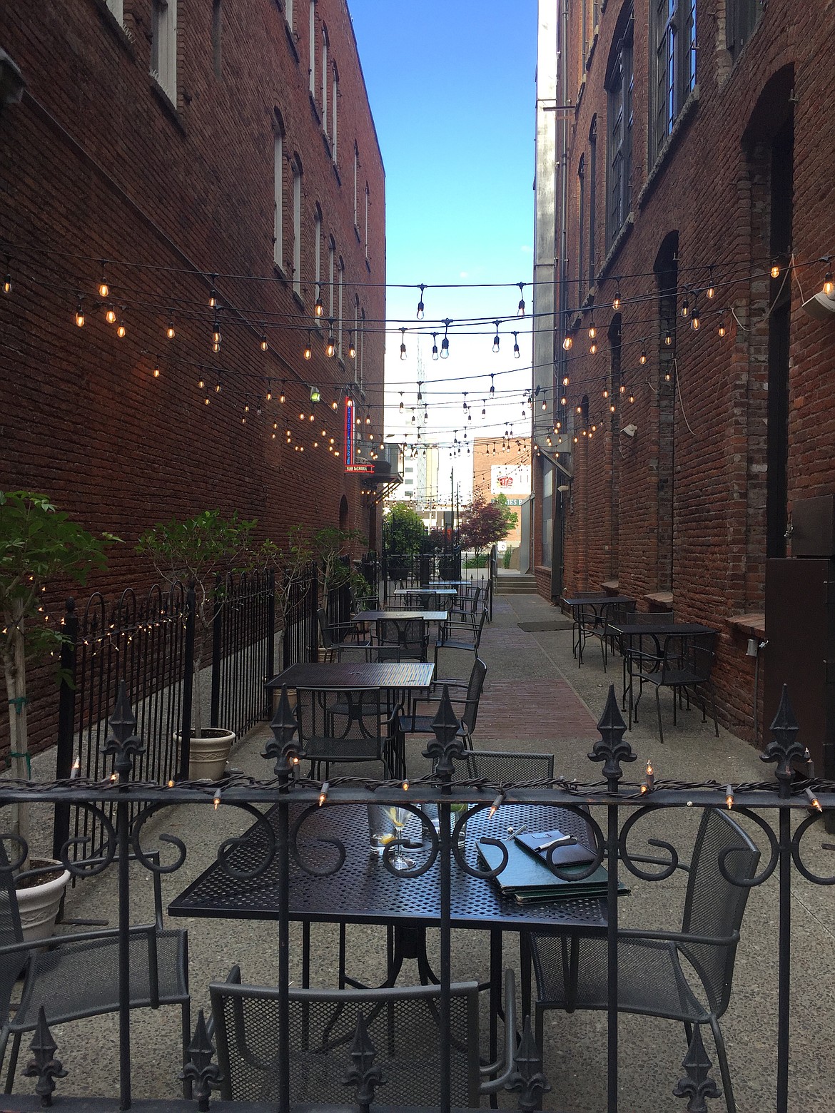 Empty tables fill the patio outside Mizuna Restaurant in downtown Spokane. Restaurants and bars in downtown Coeur d’Alene have been full of customers, despite Governor Little’s phased reopening guidelines.