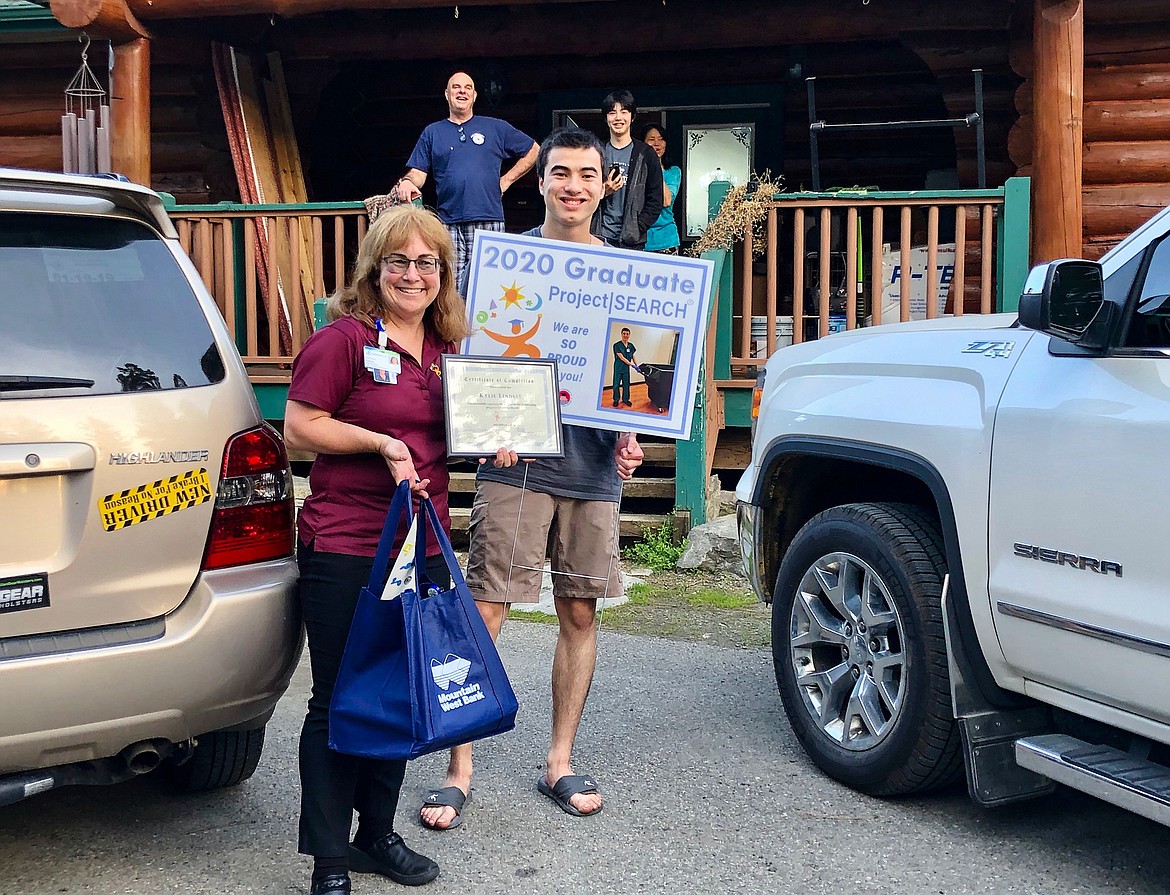 Graduate Kylie Lindsay receives his certificate of completion and a special yard sign from Project SEARCH instructor Theresa Moran on Wednesday evening. (Courtesy photo)