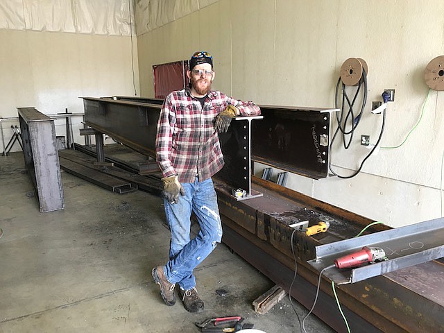 Courtesy photo 
 Brandon Lantz stands with a beam which was  fabricated at A&R Metalwork, 7791 N. Aqua in Dalton Gardens.