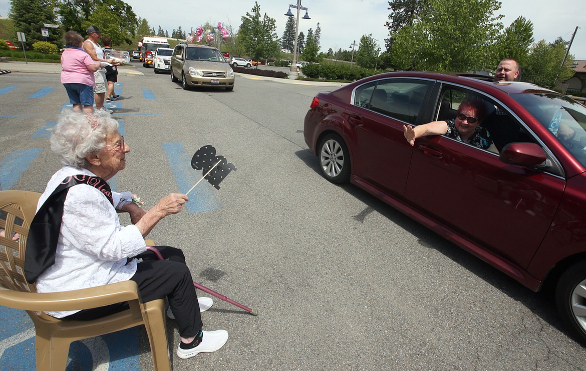 BILL BULEY/Press 
 Elmarie Waterhouse greets Georjean Kuntz, with son Kevin Kuntz peeking out the sunroof, during her 100th birthday party on Saturday outside Post Falls City Hall.