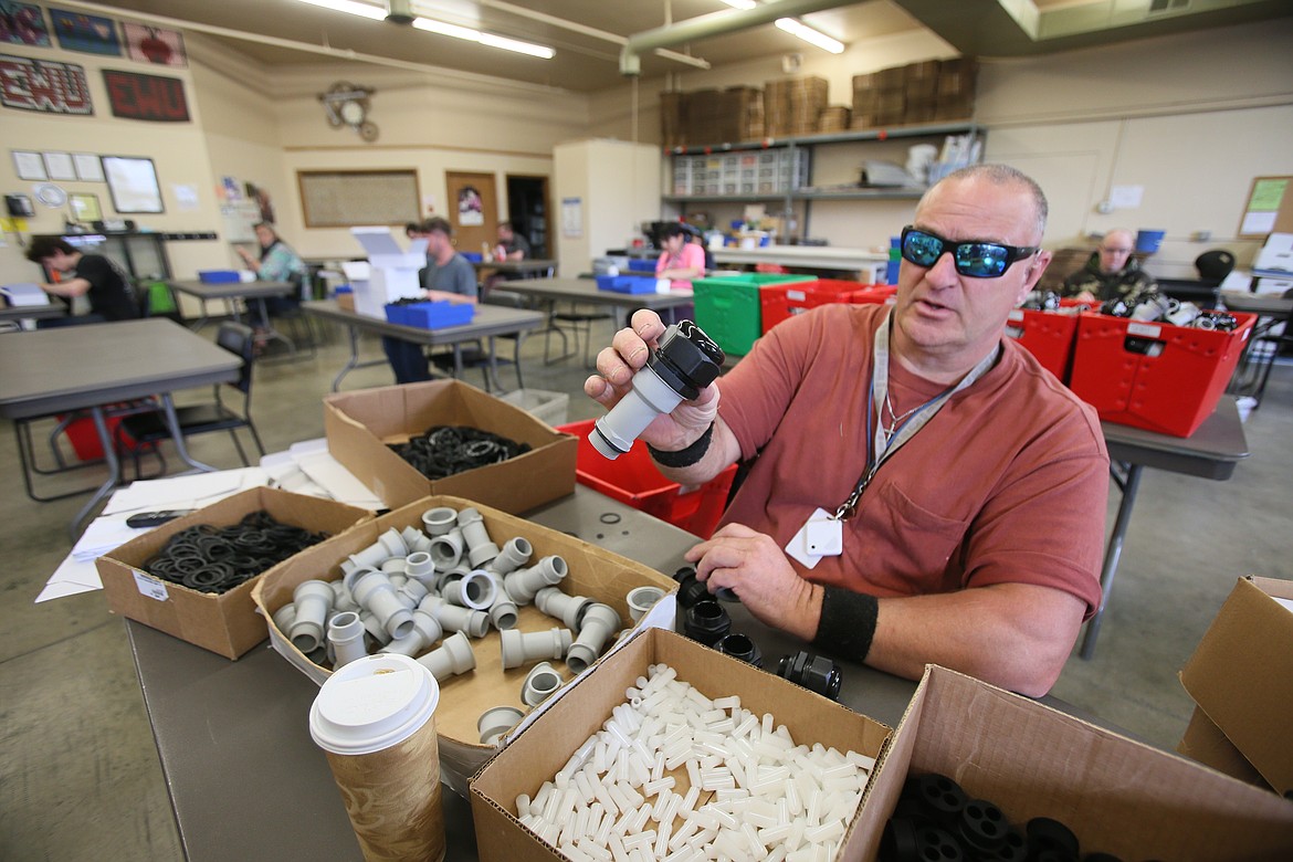 Tesh employee Jeff Shields assists with assembling pieces for cellphone tower surge protectors Monday in the vocational center. Tesh has returned to its normal business hours after six weeks of closure and a few weeks of limited staff. (DEVIN WEEKS/Press)