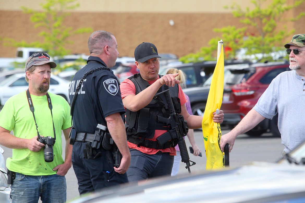 BILL BULEY/Press 
 Trevor Treller talks to a Coeur d'Alene police officer in the WinCo parking lot on Monday afternoon.