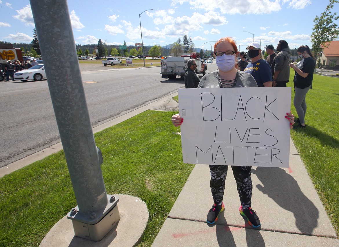 Christy Robinson protests on Appleway Avenue on Monday afternoon.