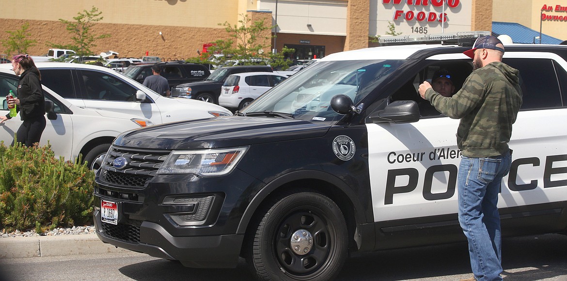 BILL BULEY/Press 
 A man talks to police outside the WinCo store on Monday afternoon.