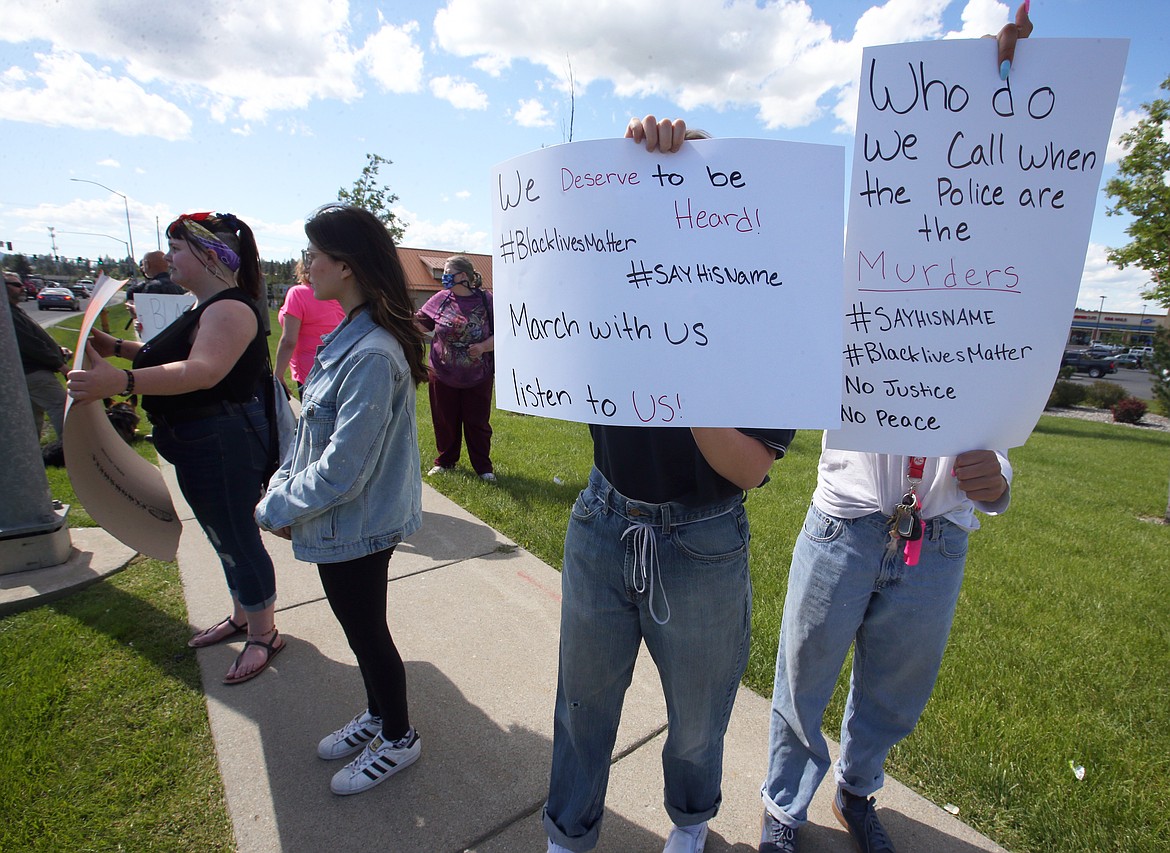 Protesters hold up signs along Appleway Avenue on Monday.