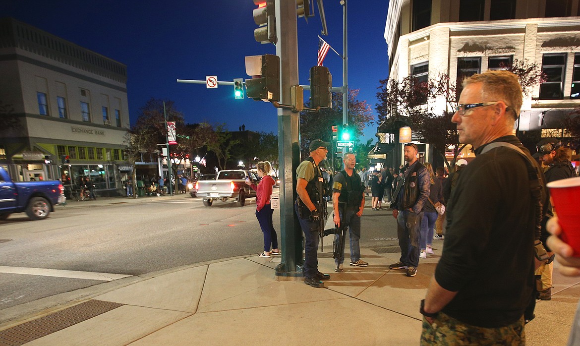 BILL BULEY/Press 
 Men with weapons guard Fourth and Sherman in Coeur d'Alene Monday night.