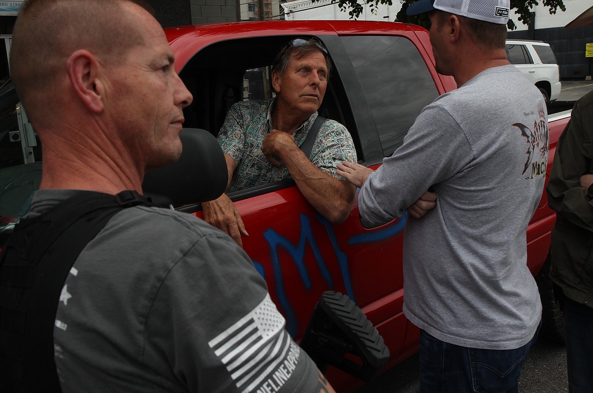Dan Carson (left) and Brett Surplus explain to Bob Dorn (middle) that both the armed men and women who gathered in downtown Coeur d’Alene Tuesday evening, and Black Lives Matter supporters, were there to gather peacefully and to prevent agitation and violence. Dorn, who had earlier hecked the crowds, apologized.
RALPH BARTHOLDT/Press