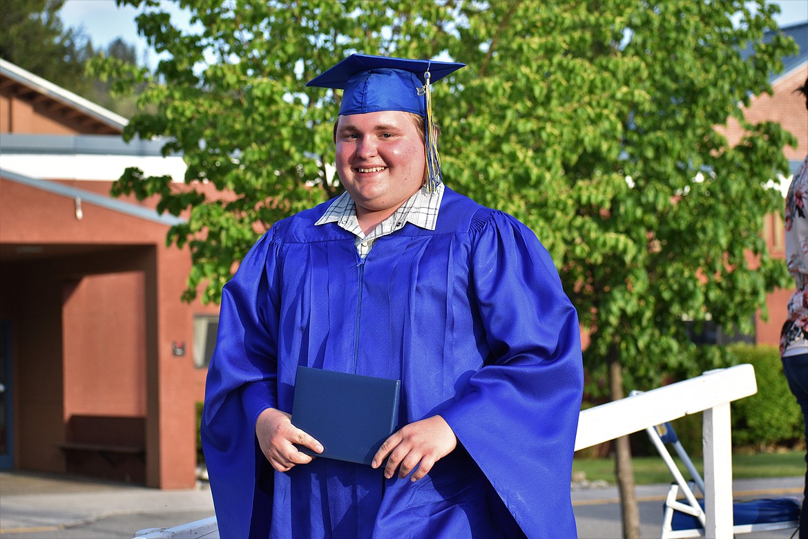 (Photo by DYLAN GREENE) 
 Charlie Abbott smiles after receiving his diploma.