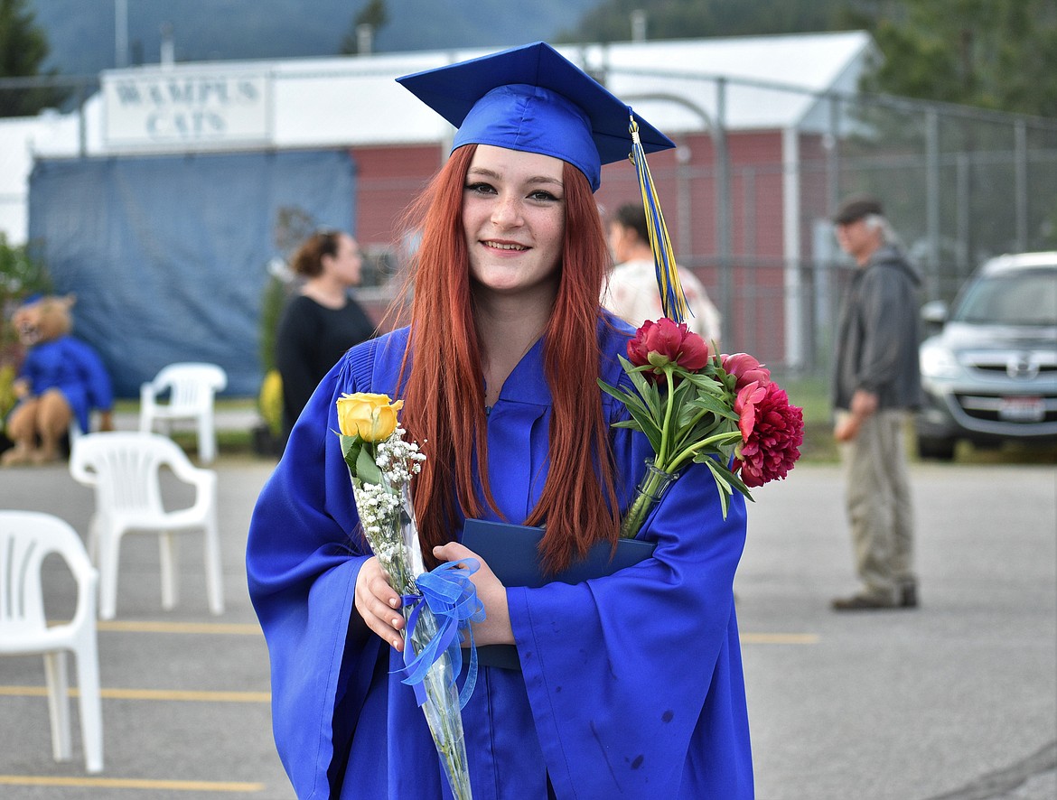 (Photo by DYLAN GREENE) Leslie Montgomery walks back to celebrate with her family after the graduation ceremony.