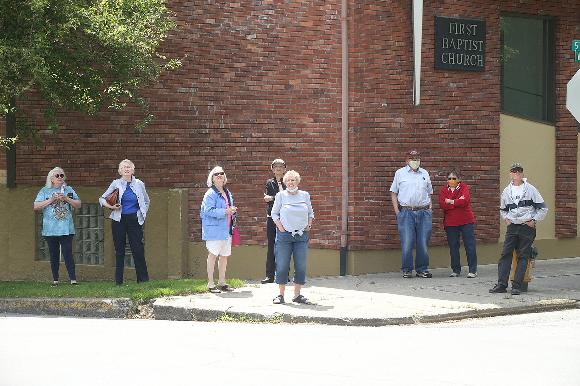 People watch the new cross being put on the steeple at St. Luke’s Episcopal Church on Thursday.