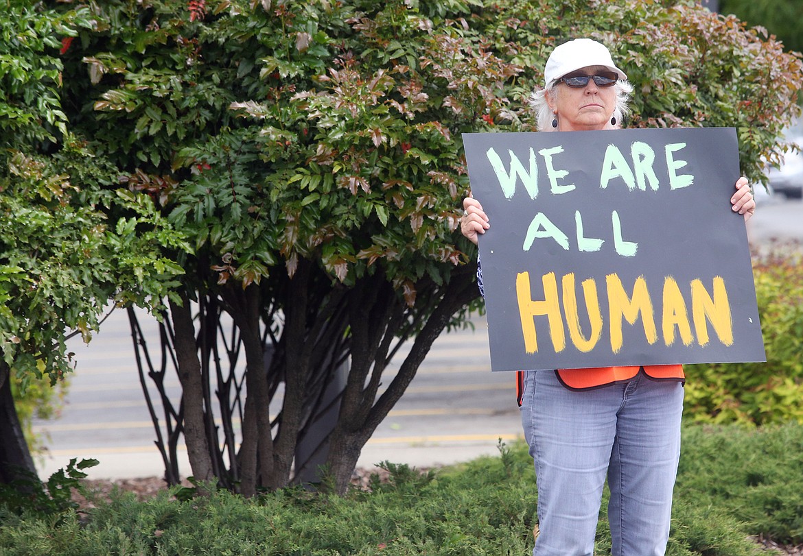 BILL BULEY/Press 
 Jan Studer holds a sign during a rally for peace at U.S. 95 and Appleway Avenue onThursday.