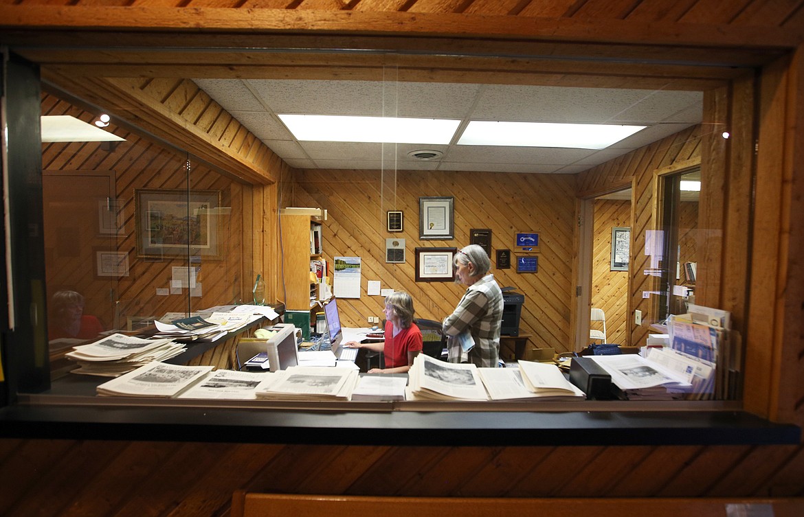 BILL BULEY/Press 
 Volunteer Becky Power stands behind museum director Dorothy Dahlgren as they work in the main office at the Museum of North Idaho on Friday morning.