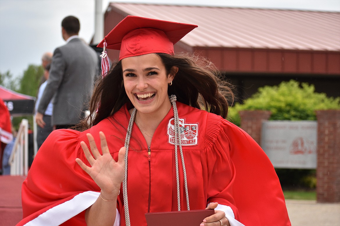Jenny Slaveck waves after crossing the stage and grabbing her diploma.