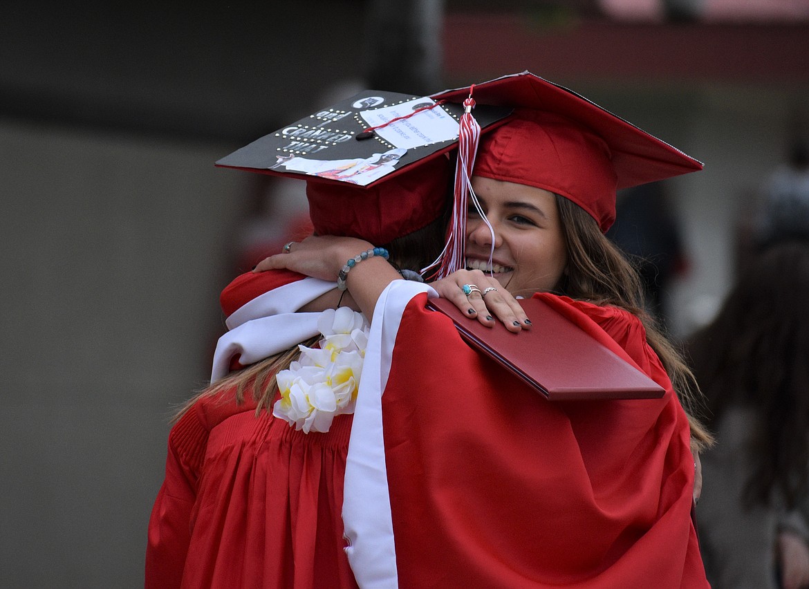 Hadley Goodvin (right) embraces Sage Saccomanno after crossing the stage and receiving their diplomas.