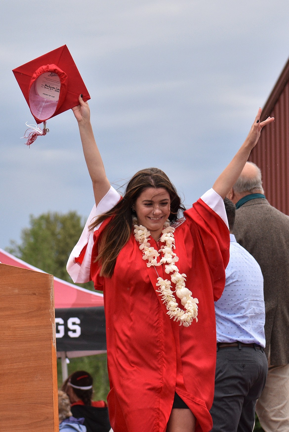 (Photo by DYLAN GREENE) 
 An SHS graduate throws her hands in the air as she crosses the commencement stage.