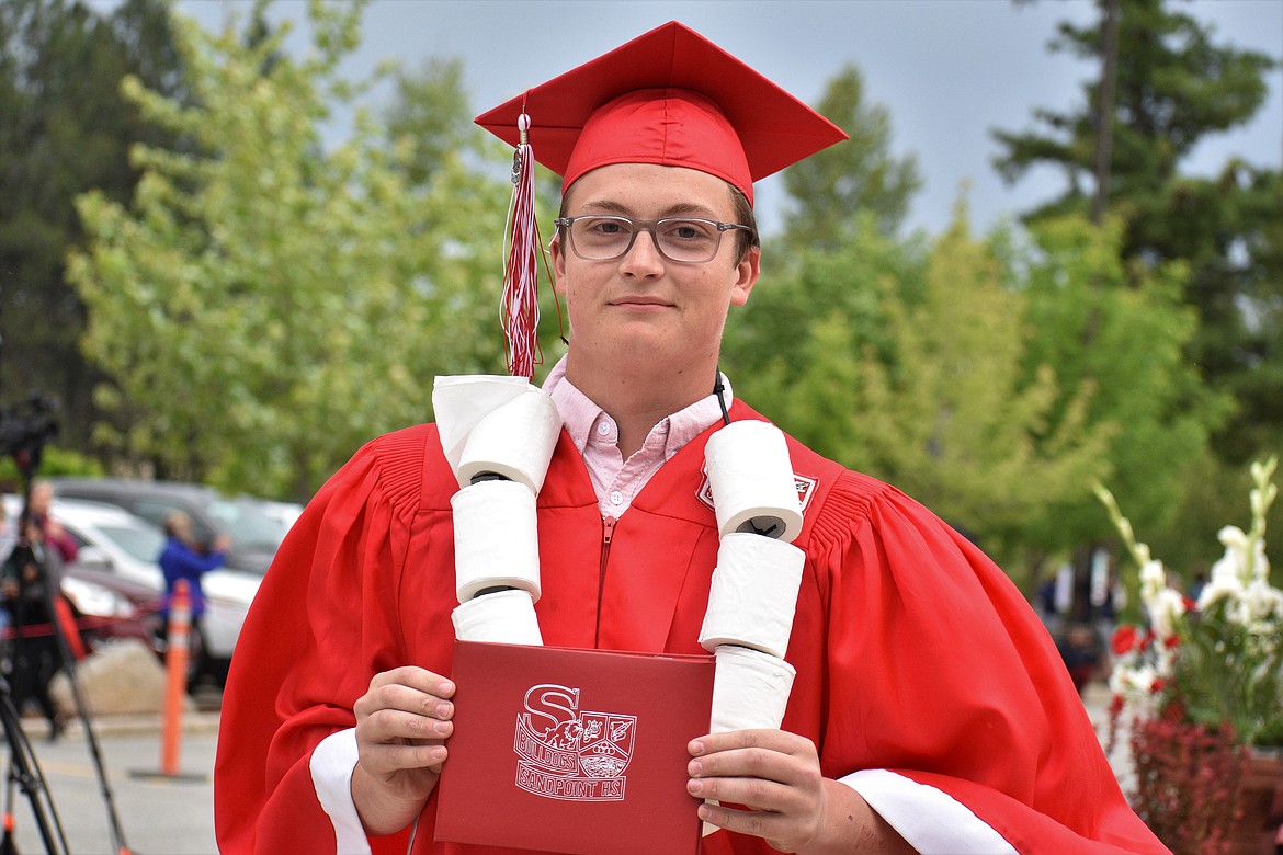 (Photo by DYLAN GREENE) 
 Jackson Prior poses for a photo with his diploma and toilet paper roll necklace.