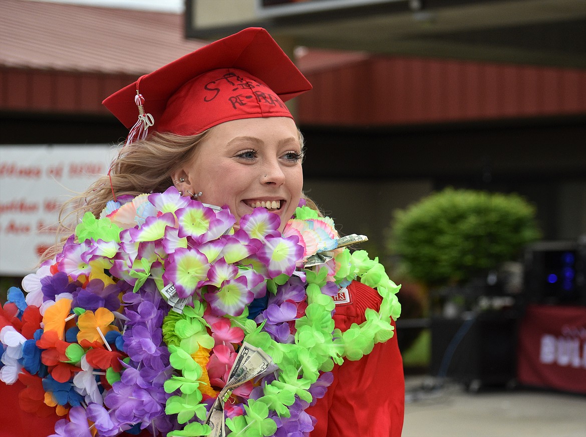 (Photo by DYLAN GREENE) 
 An SHS grad with a colorful lei smiles after receiving her diploma.