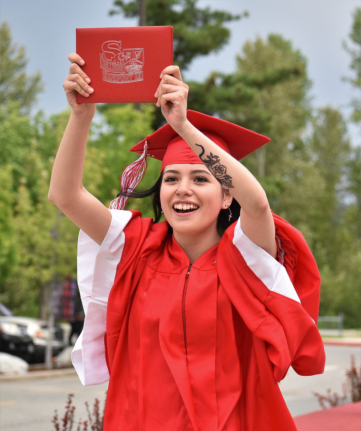 (Photo by DYLAN GREENE) 
 An SHS graduate holds her diploma high in the air after crossing the stage on Friday.
