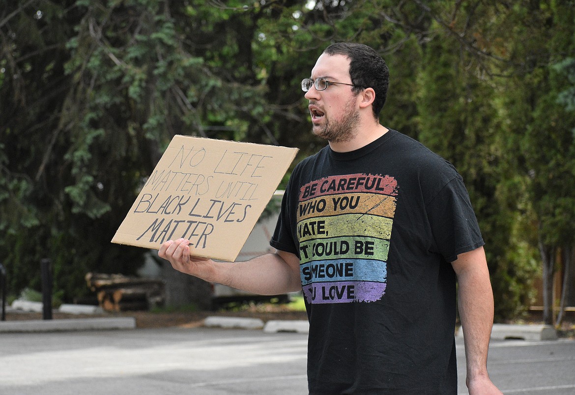 (Photo by DYLAN GREENE) 
 Caleb Giard holds a sign and chants "Black Lives Matter," during Saturday's protest.
