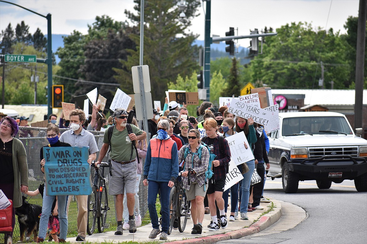 (Photo by DYLAN GREENE) 
 Protesters head down Pine Street on Saturday.