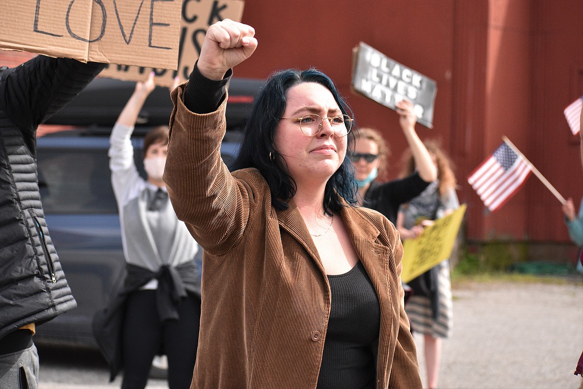 (Photo by DYLAN GREENE) 
 A protester holds up their fist while chanting, "no justice, no peace."
