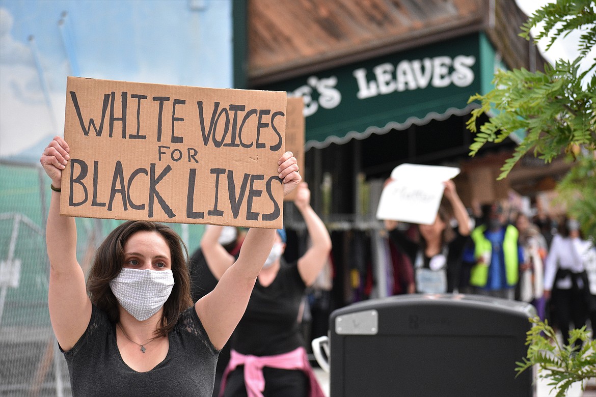 (Photo by DYLAN GREENE) 
 A protester holds a sign that says, "white voices for black lives."