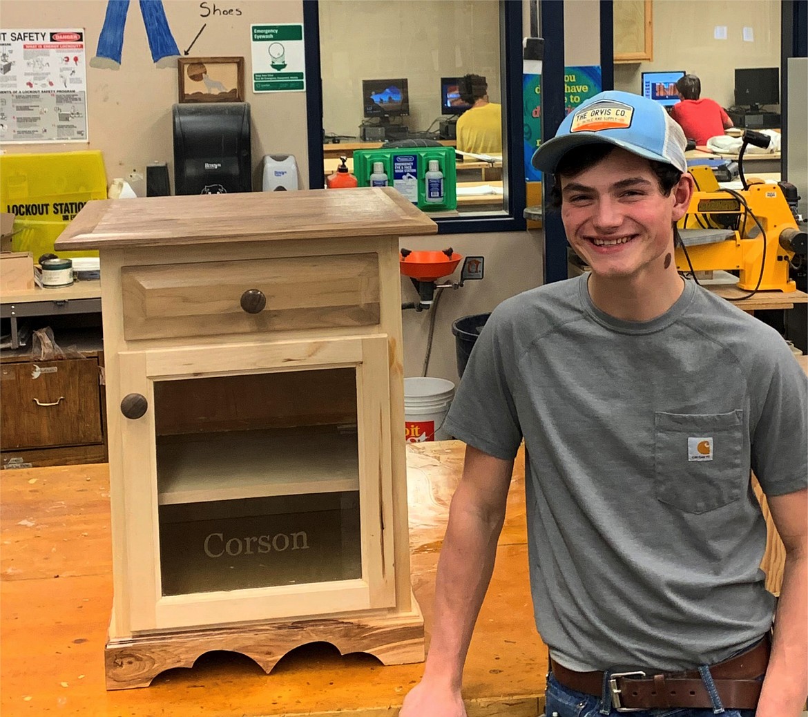 Brint Corson (senior) and his first semester cabinet. Brint incorporated skills from both CMM2 and 3 as he completed this project. He learned cabinet construction in CMM2, but also learned the CMM3 advanced glass etching skill and etched the glass panel on his cabinet door. He also used the lathe to turn his own door and drawer knobs.