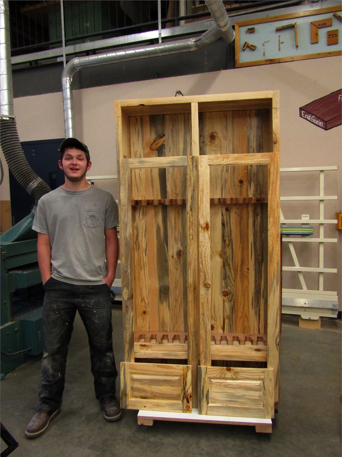 Cody Kerstiens and his 6-foot-tall blue pine gun cabinet. He constructed this project with North Idaho blue pine. It holds up to 12 guns, and has storage in the base. His upper doors are prepared for glass panels. As part of his advanced skill he was going to incorporate glass etching into each of the panels; but he was not able to do complete the etching with school closures.