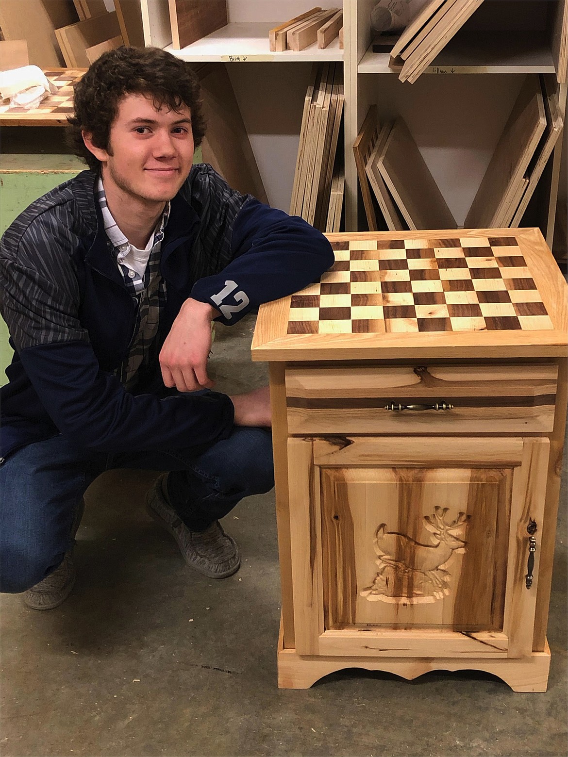 Hayden Stockton (junior) and his first semester cabinet project. He incorporated his CMM1 chessboard project into the cabinet as the cabinet top. He also used multiple woods on the drawer front to give the cabinet a unique look.