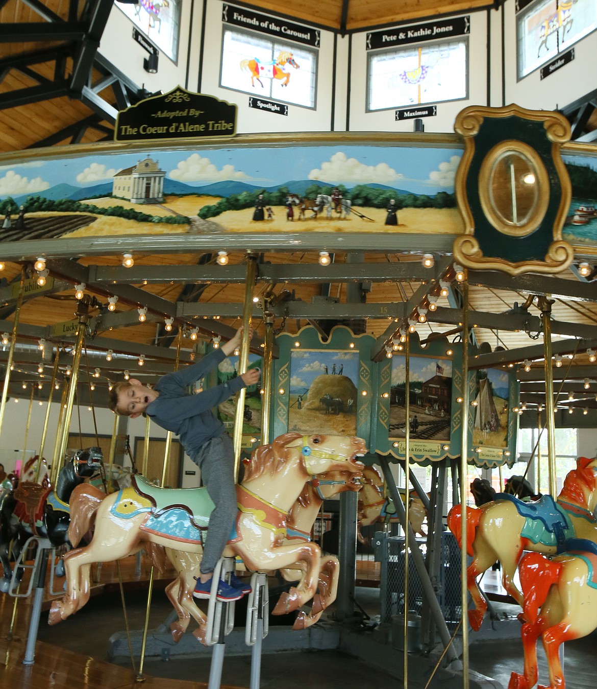 Juju Doalson, 7, goofs around while riding the Coeur d'Alene Carousel on Monday. The carousel has returned to summer hours and is now open seven days a week. (DEVIN WEEKS/Press)