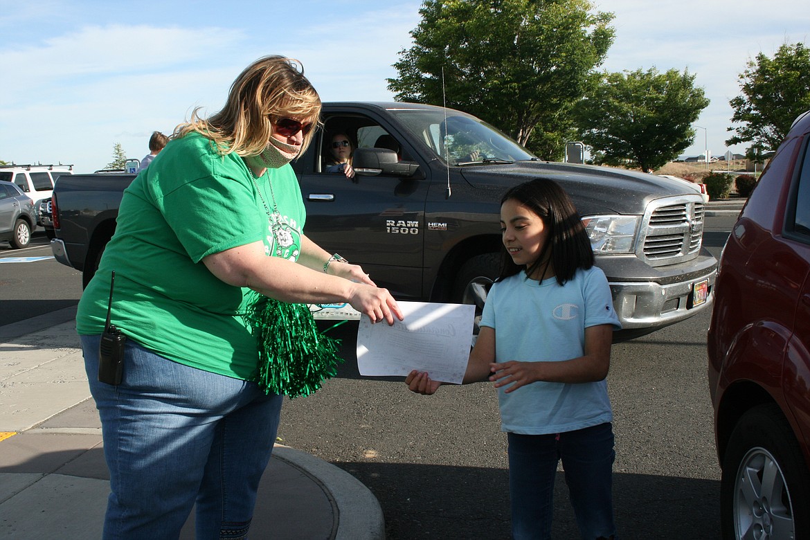 Cheryl Schweizer/Columbia Basin Herald 
  
 Park Orchard principal Cheri Ward presents a fifth-grader with her promotion certificate during the school's promotion parade Monday.