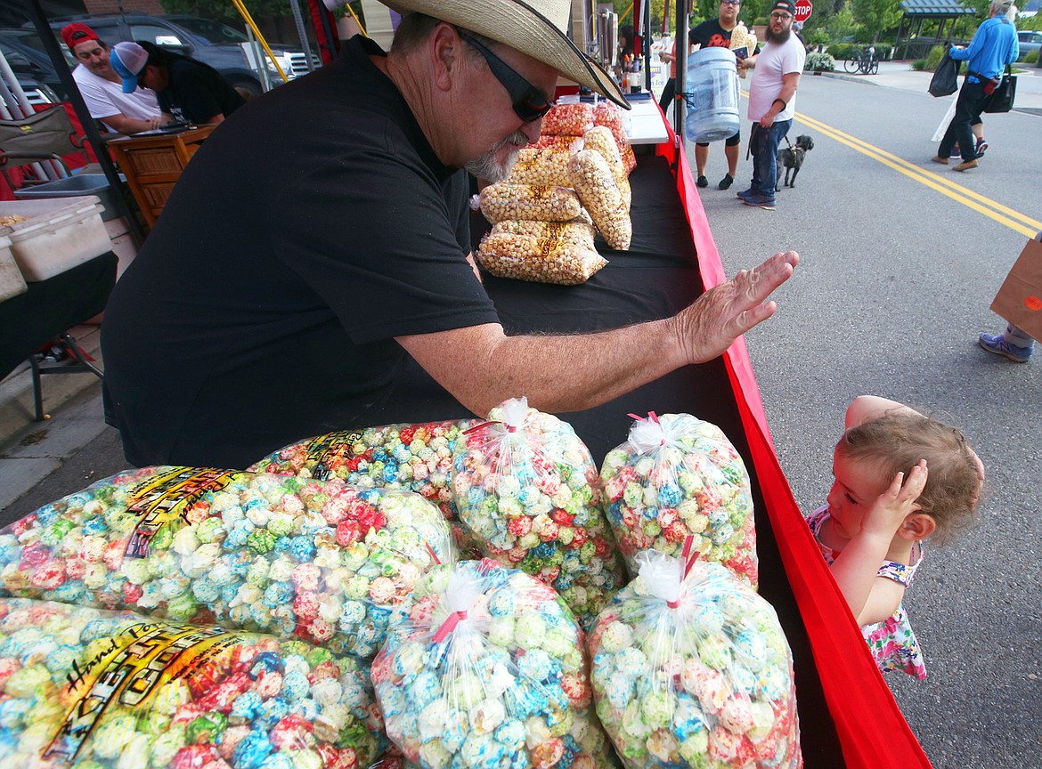 BILL BULEY/Press 
 JB Houlihan offers a high five to Julia Joy at the farmer's market in downtown Coeur d'Alene Wednesday.