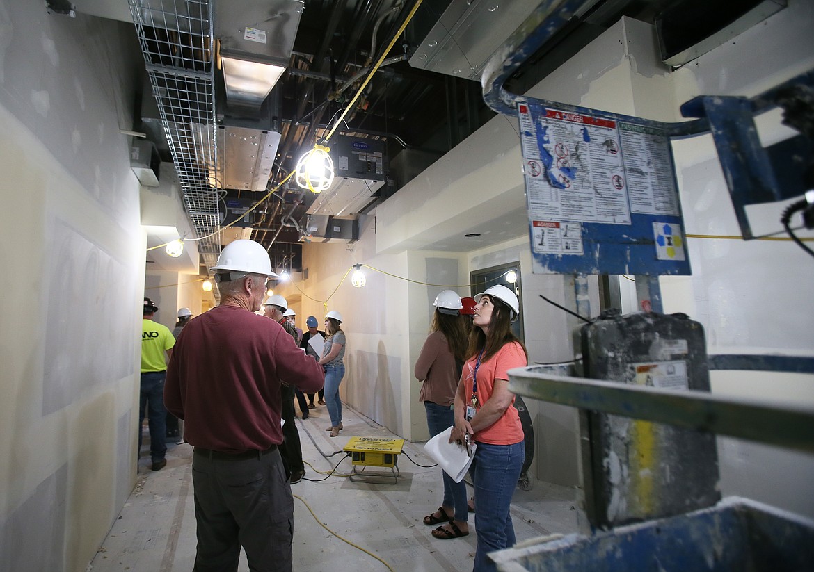 Northwest Expedition Academy office manager Michelle Olson, right, looks into the second-story ceiling of the new school during a tour Wednesday. NExA is moving out of the old Hayden Lake Elementary School building on Government Way into the spacious new school on Prairie Avenue this fall. (DEVIN WEEKS/Press)