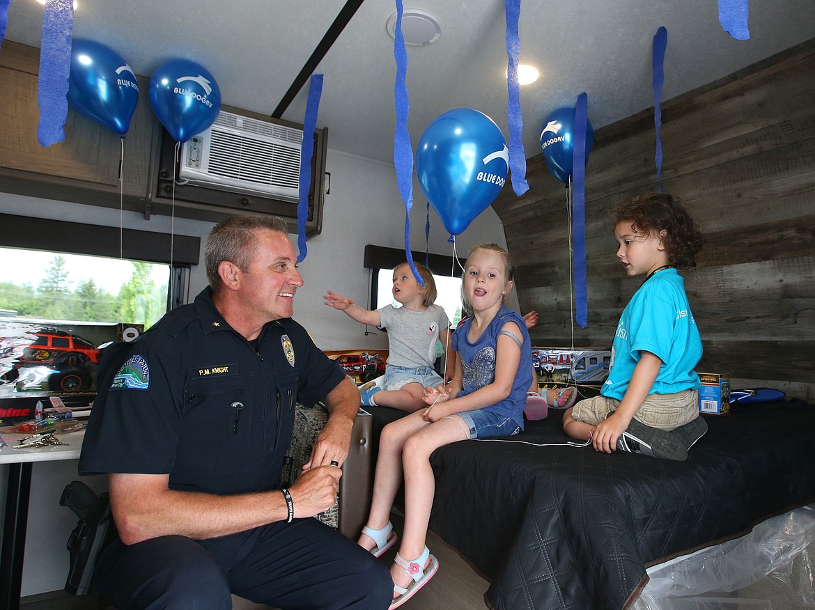 Post Falls Police Chief Pat Knight talks with Christopher Blood as he checks out his family’s new RV courtesy of the Make-A-Wish Foundation on Thursday at Blue Dog RV. Christopher is joined by friends Rebecca Fryberger, holding balloon, and Abigail Fryberger.