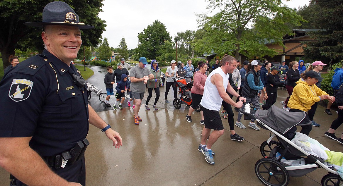 BILL BULEY/Press 
 Idaho State Police Capt. John Kempf watches at participants in the ISP Foot Pursuit begin the 5K fun run on Saturday at McEuen Park.