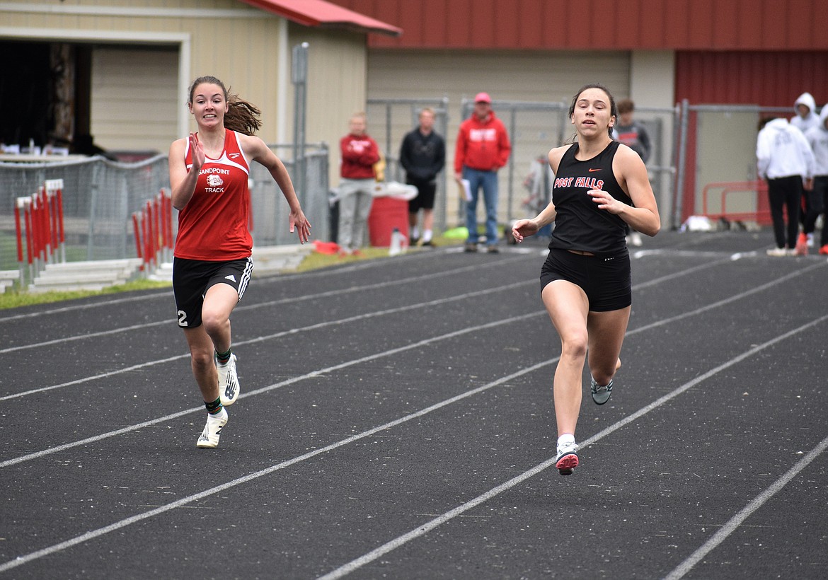 Post Falls senior Katie Fleming, right, bests Sandpoint’s Anna Reinink in the girls 100 meters.