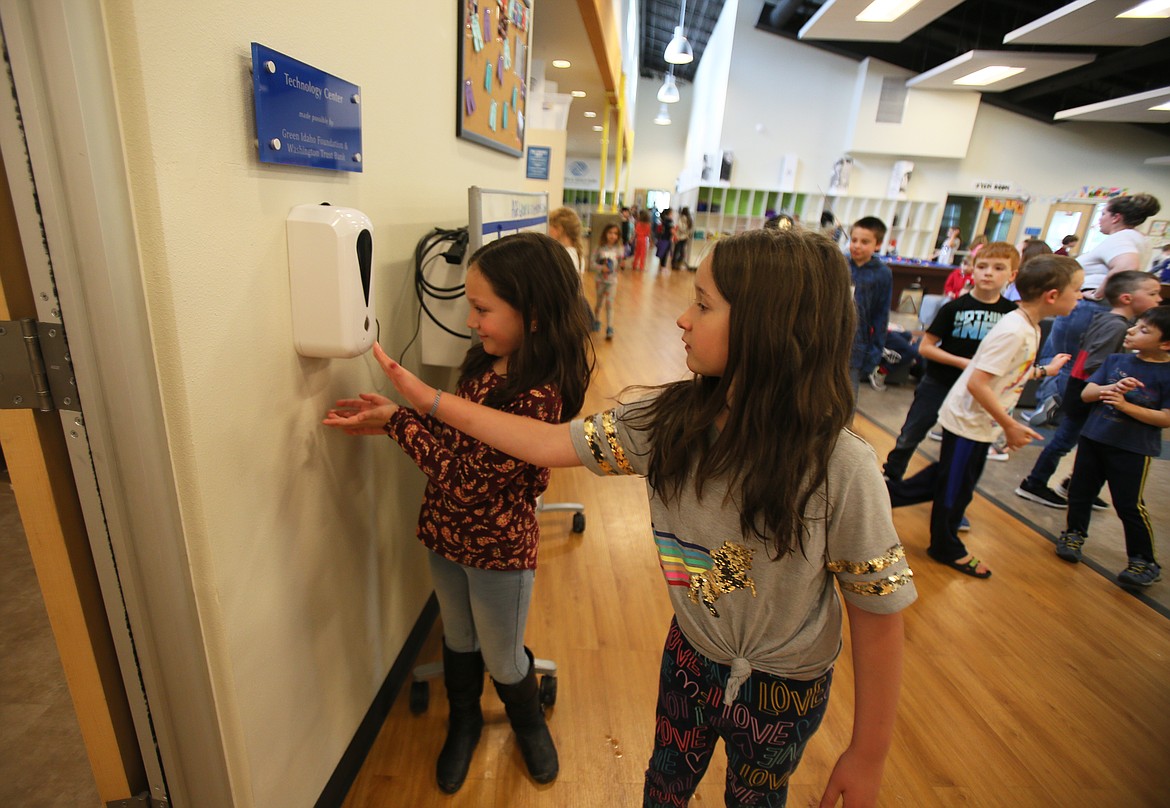 Lida Depriest, 8, right, and Brooklynne Denny, 7, on Tuesday use a hand sanitizer pump recently installed in the Boys and Girls Club in Coeur d'Alene. The Boys and Girls Club of Kootenai County received $6,000 from the COVID-19 Community Response and Recovery Funds for North Idaho and Eastern Washington, which distributed $746,012 in its second round of grants. (DEVIN WEEKS/Press)