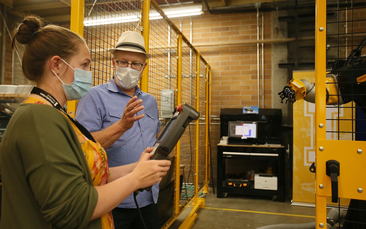 John Shovic, a computer science professor with the University of Idaho Coeur d’Alene, shows Priest River Elementary sixth-grade teacher Allison Inge how to control the 800-pound, $450,000 FANUC robot in the North Idaho College Venture Center during a demonstration on Wednesday. About a dozen teachers attended the demo to learn about new programs and tech at the U of I Coeur d’Alene.