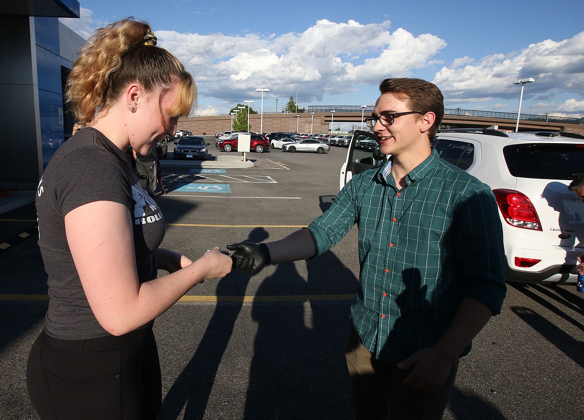 Brian Hansen hands Amy Palmer the key to the 2019 Chevy Trax right after he won it Thursday at Knudtsen Chevrolet in Post Falls.